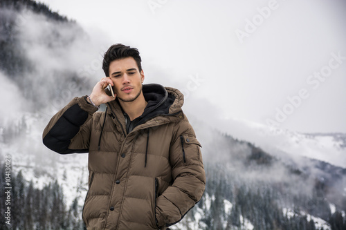 Young man in at mountain using cell phone