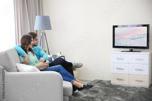 Young couple watching TV on...