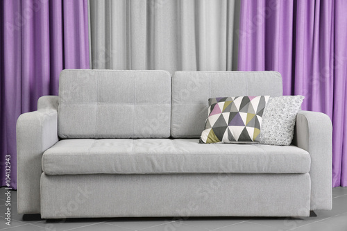 Grey sofa against blue curt...