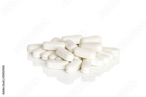 Calcium Vitamin Supplements. A pile of calcium vitamin supplement tablets isolated on a white background.