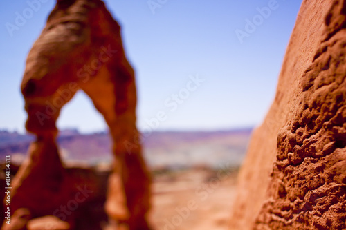 abstract view with delicate arch of Utah in bokeh, closeup focus on sandstone texture near lens © Chris Gardiner