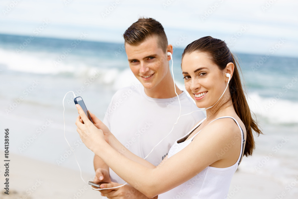 Couple of runners with mobile smart phones outdoors