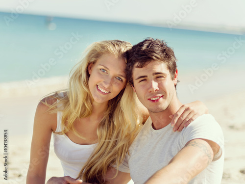 Romantic young couple sitting on the beach © Sergey Nivens