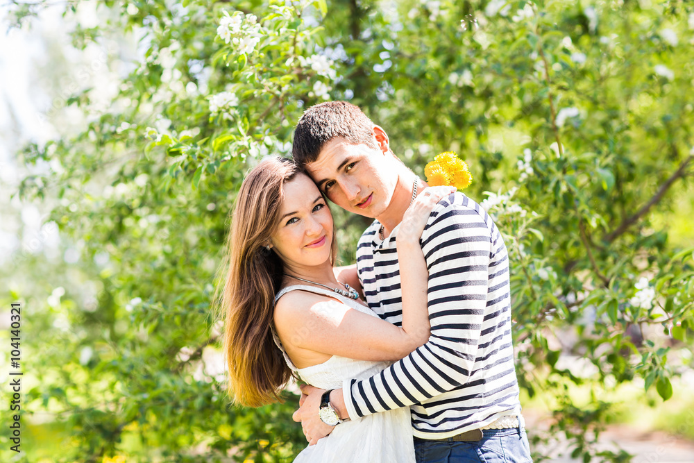 Romantic young couple standing under blossom tree Romantic young couple standing under blossom tree