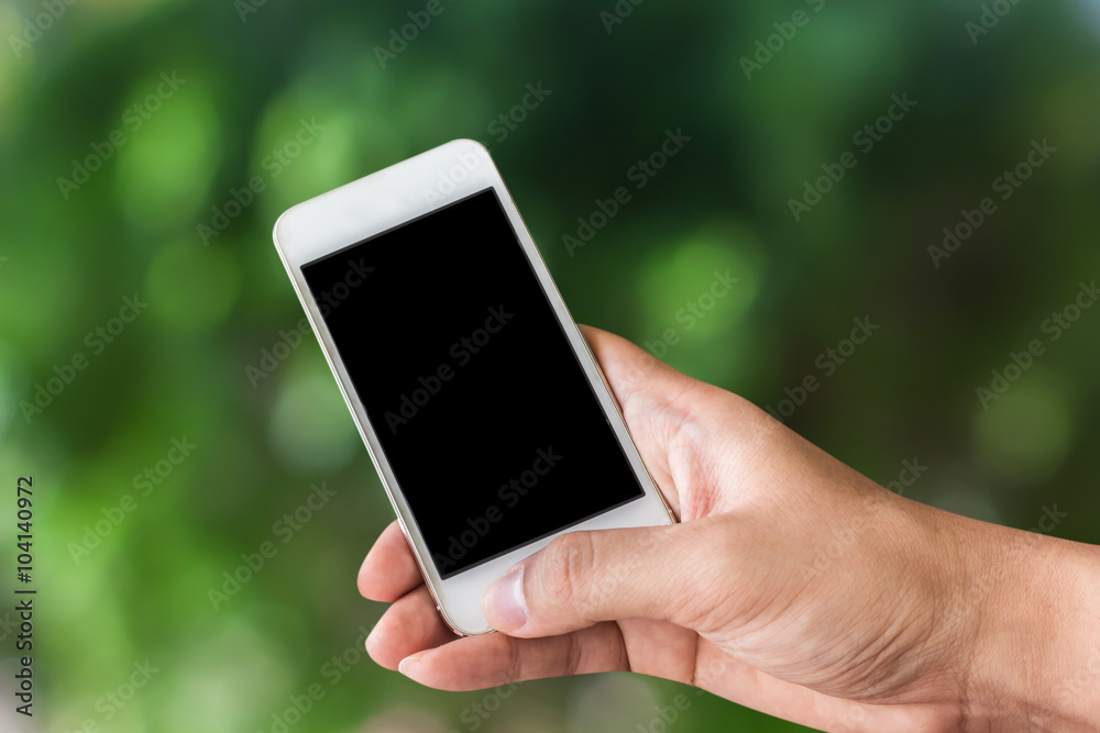 Hand holding smartphone on green background