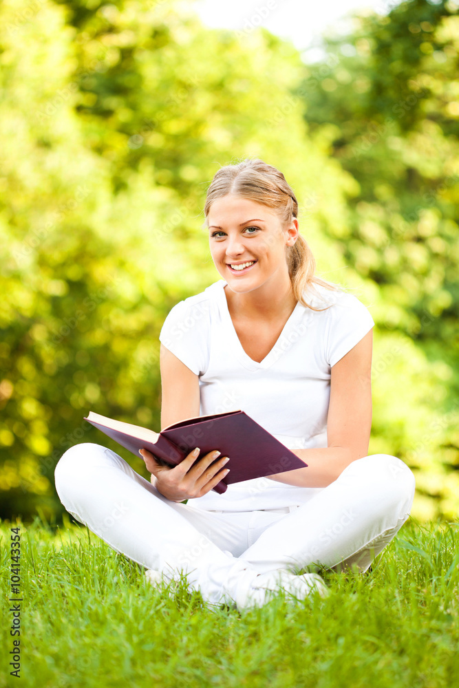 Young woman reading book in park