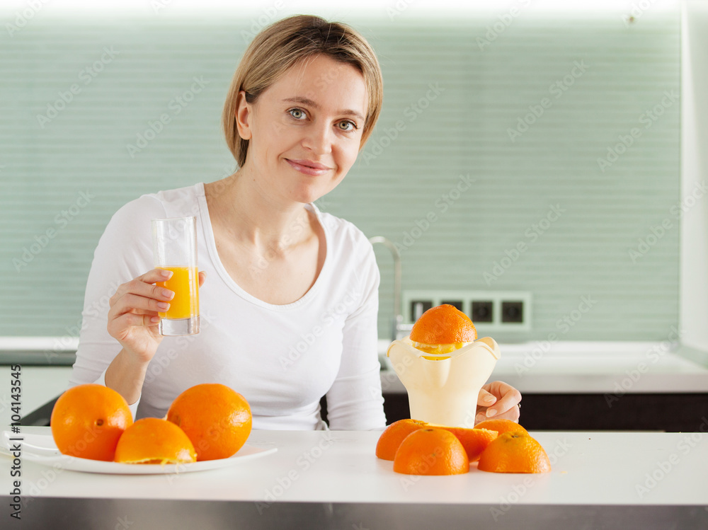 Adult woman cooking orange juice on juicer