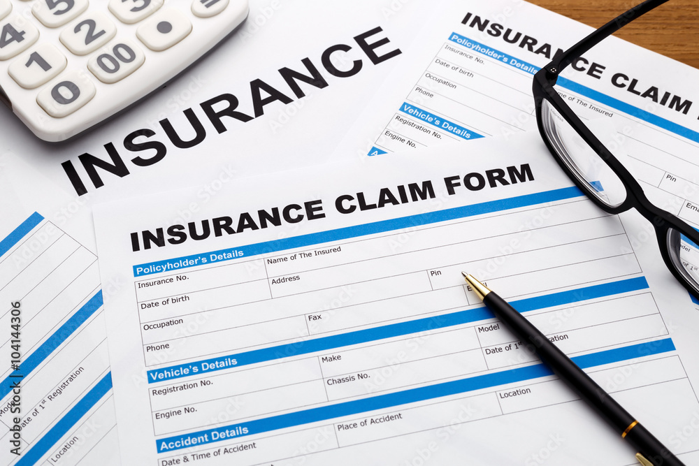 Insurance claim form with pen and calculator