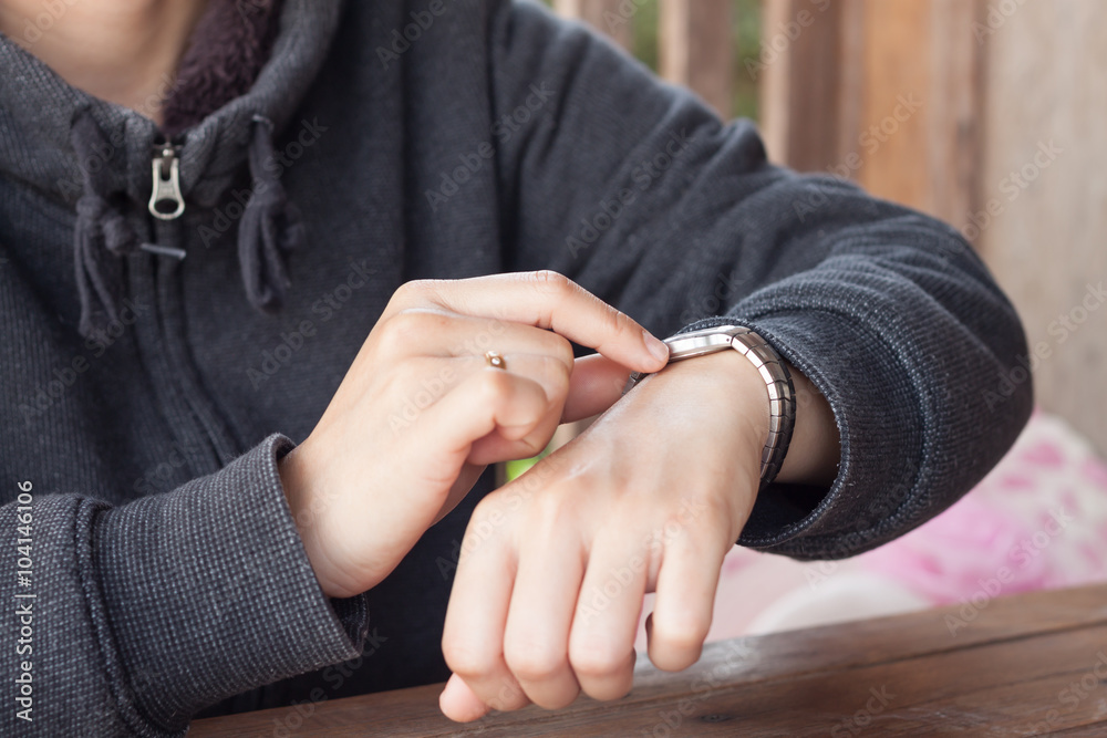 Woman checks the time on a wrist watch