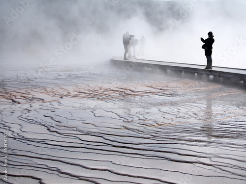 Obraz na plátne Warm, wet mist hovers over boardwalk, concealing shadowy figures and dropping moisture on bridge