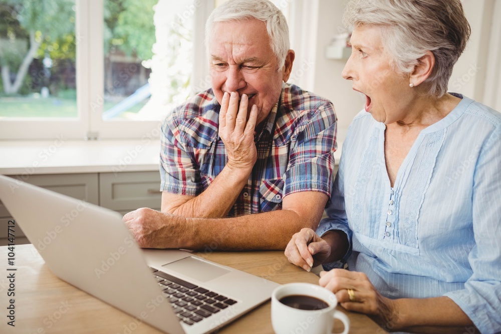 Surprised senior couple using laptop Surprised senior couple using laptop