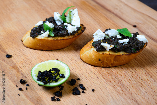 bruschetta Tapenade, with olives on old wooden Board