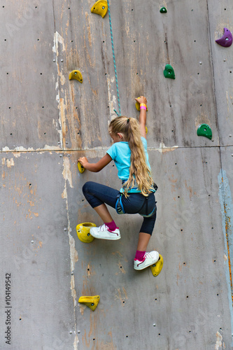 Young girl climbing a wall