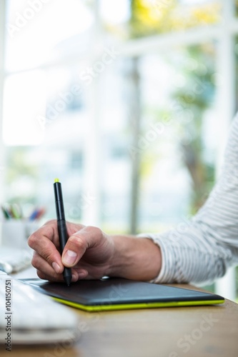Masculine hands writing on digital tablet