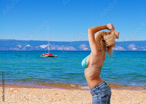 Girl in a blue bikini on the beach.
