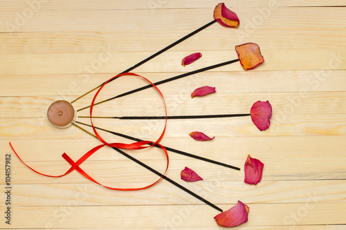 five incense sticks and dry rose petal flat lay