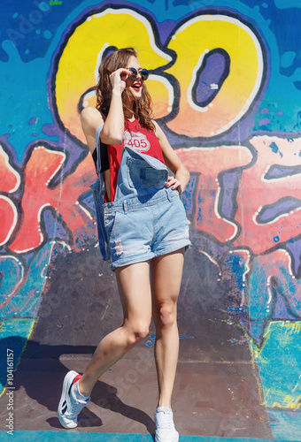 Hipster girl in the jeans and sunglasses outdoor