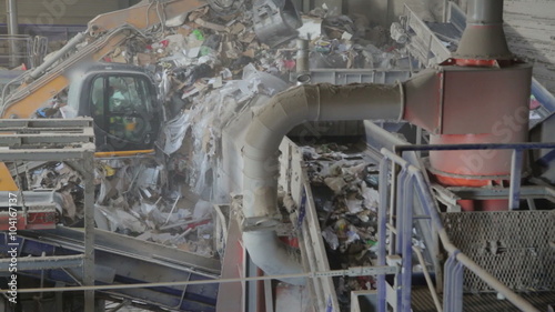 Paper and plastic being sorted out automatically on a recycling belt