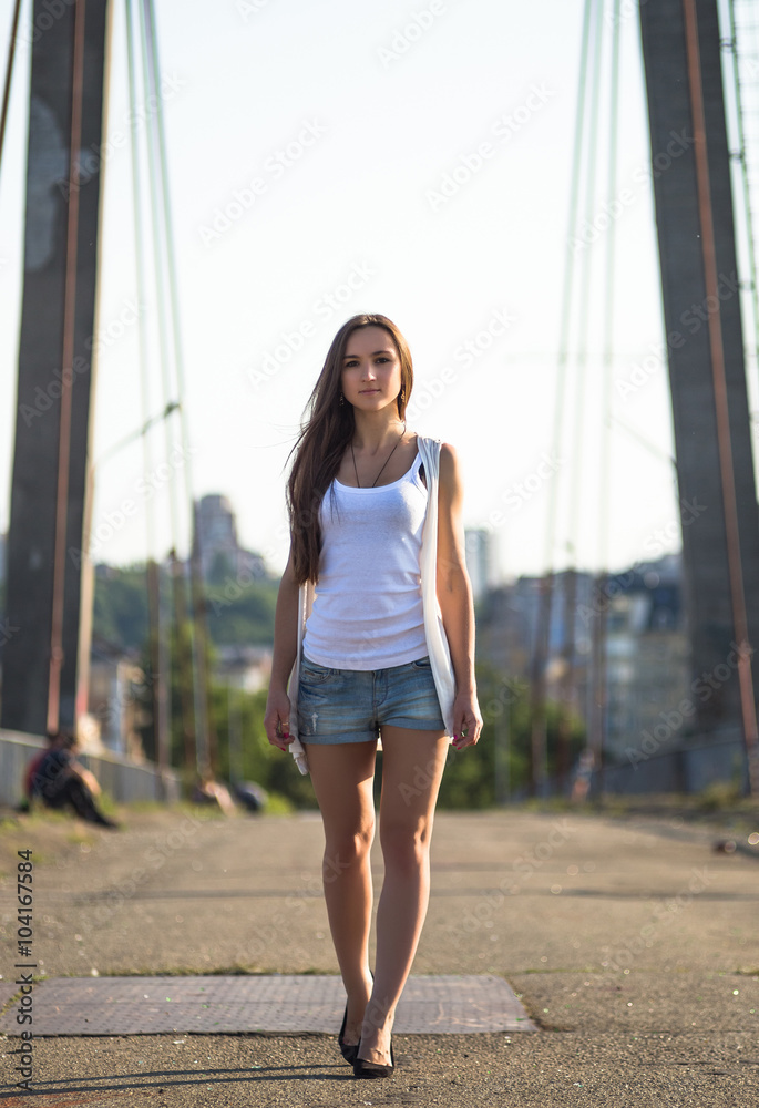Young happy caucasian woman walkong on old bridge in city park outdoor. Relax lifestyle summer concept Young happy caucasian woman walkong on old bridge in city park outdoor. Relax lifestyle summer concept