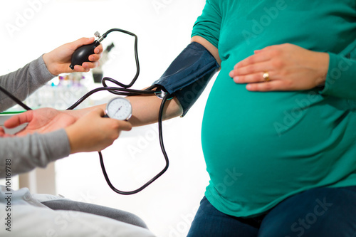 Doctor measures the pressure of a pregnant woman