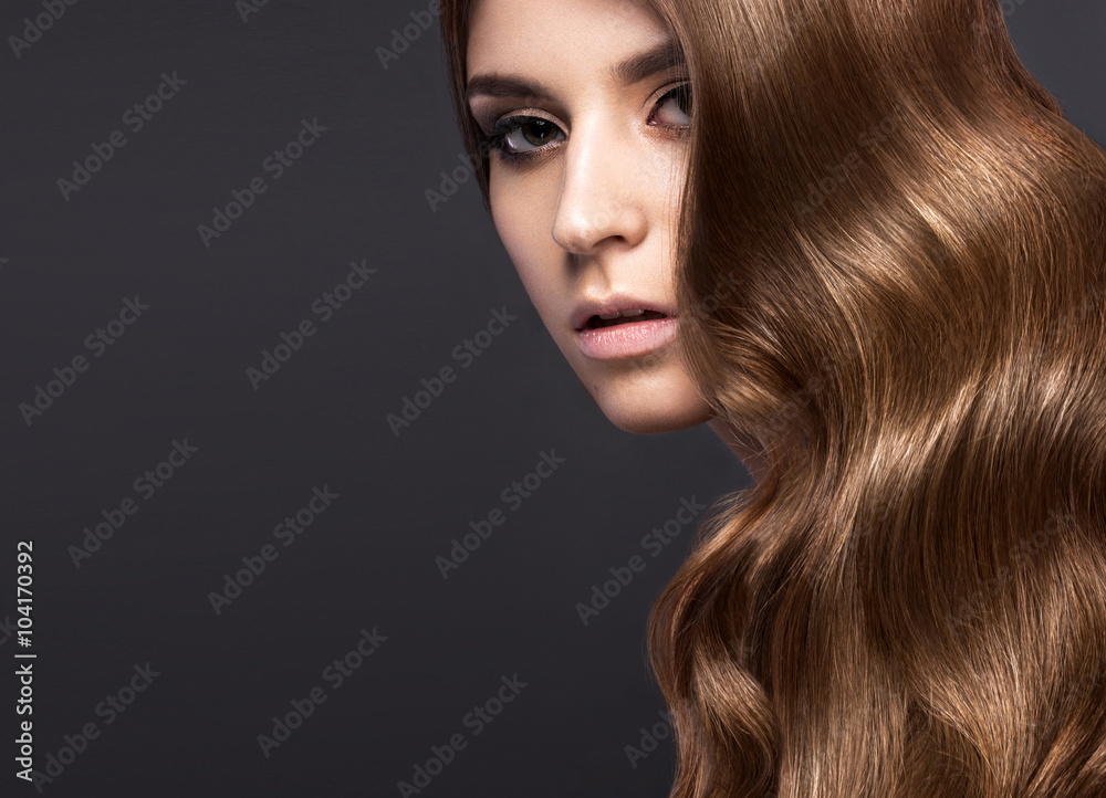 Beautiful brunette girl with a perfectly curls hair and classic make-up. Beauty face. Beautiful brunette girl with a perfectly curls hair and classic make-up. Beauty face.