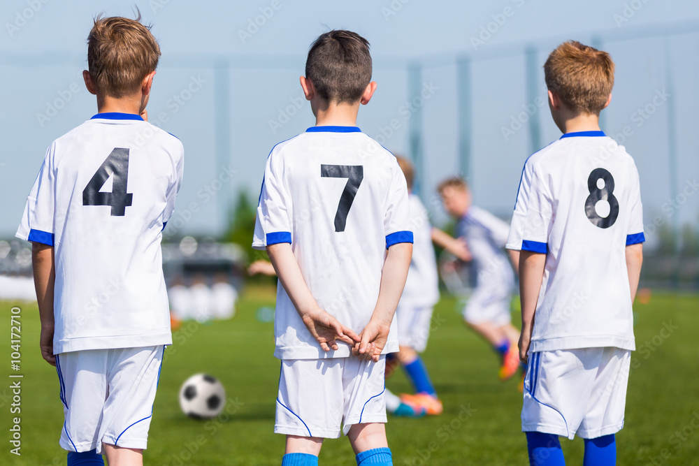 Fototapeta premium Youth Soccer Team; Reserve Players on a Bench; Boys Ready To Play European Football Match.