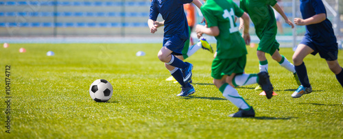 Boys play soccer match. Blue and green team on a sports field © matimix
