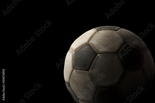 Old Soccer Ball on Black Background   Detail of a old black and white soccer ball on a black background with dark shadows
