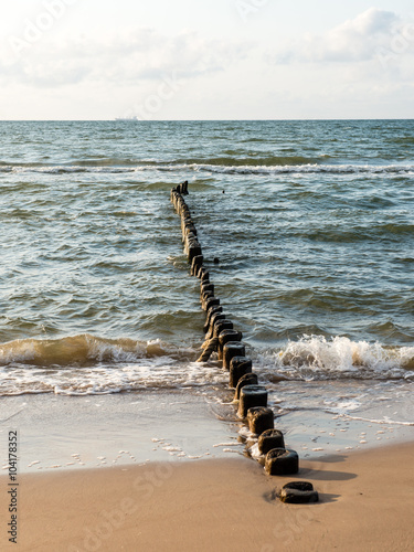 Breakwater of one row of wooden poles at the Sea coast