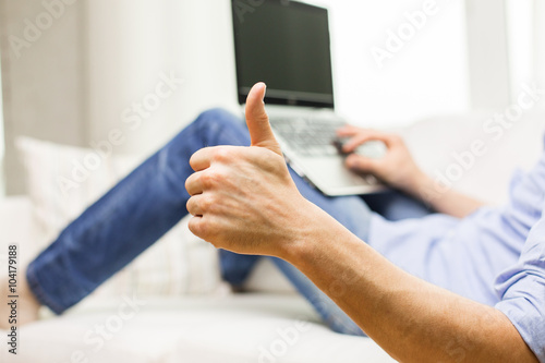 close up of man typing on laptop at home