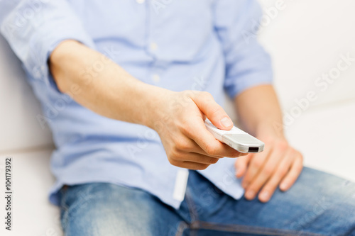 close up of man with tv remote control at home