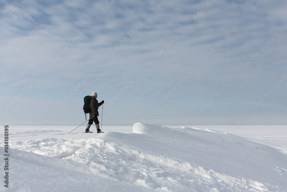The man the traveler with a backpack skiing on snow of the froze