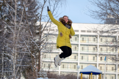 Happy girl jumps high in the winter