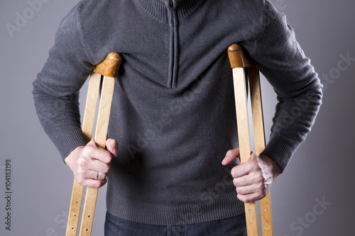 Canvas Print Man on crutches on a gray background