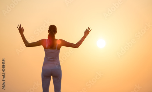 Young woman practising yoga in sunset