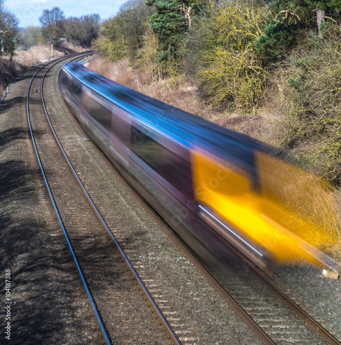 Train speeding through English countryside with motion blur