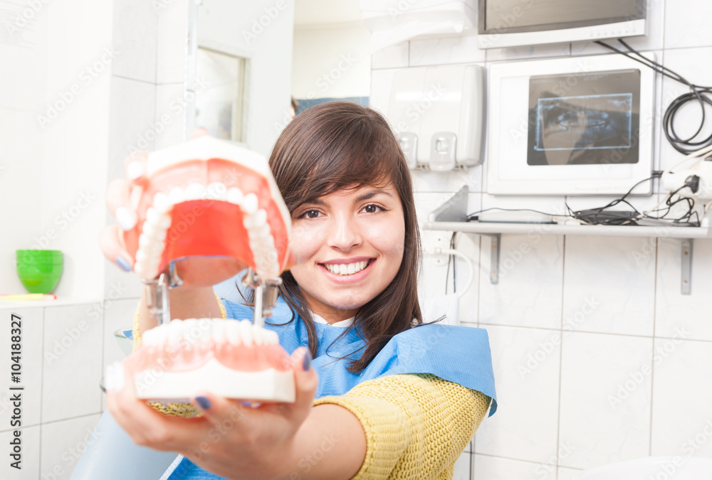 Beautiful woman with artificial jaw model in dental office Stock Photo