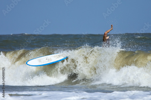 man wipeing out on surfboard