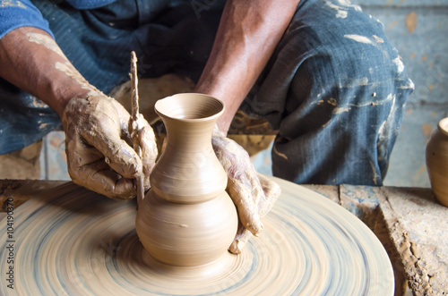 Hands of making clay pot on the pottery wheel ,select focus, close-up. © thongsan