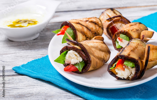 rolls of grilled slices of eggplant with feta cheese and tomato