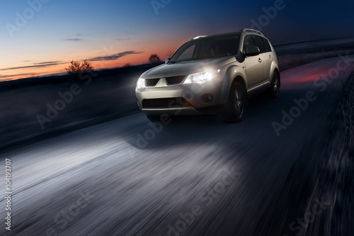 Car fast speed drive on asphalt road at dusk