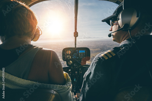 Man flying a helicopter with his copilot