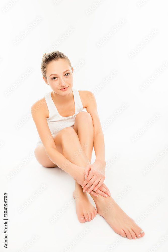 Cute pretty young woman touching her legs - obrazy, fototapety, plakaty 