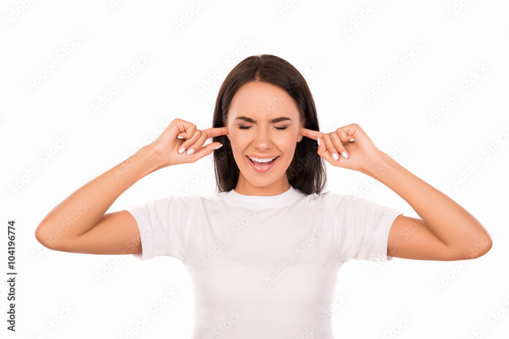 Young attractive woman covering her ears with fingers ignoring n Young attractive woman covering her ears with fingers ignoring n
