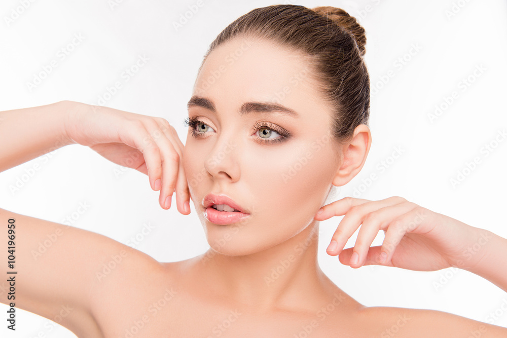 Portrait of attractive minded woman with pure skin touching chee