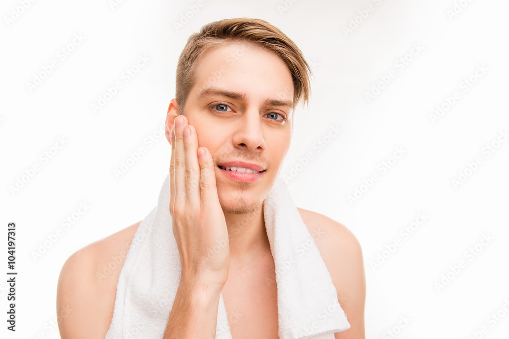 Handsome pretty young man with towel touching his face after sha Handsome pretty young man with towel touching his face after sha