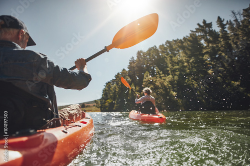 Senior couple kayaking in a lake photo