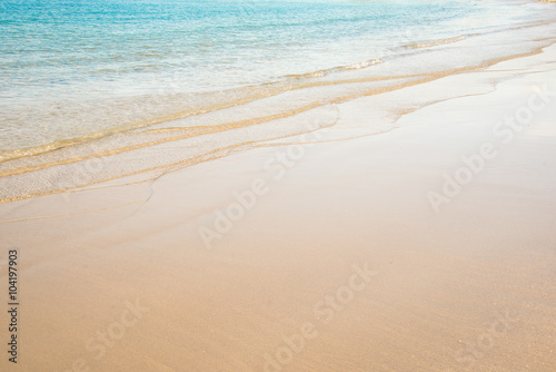 Fotografie Close up on the edge of a beach with white sand and turquoise water