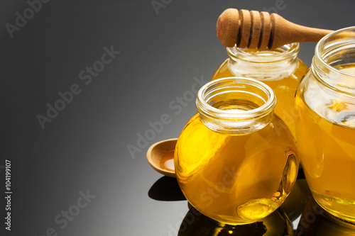 glass jar of honey on black