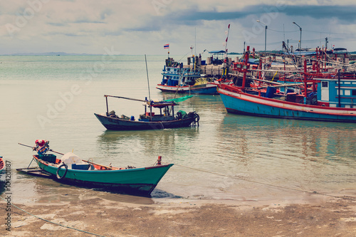 Old Harbour with fishing boats, ship and docks in Thailand.